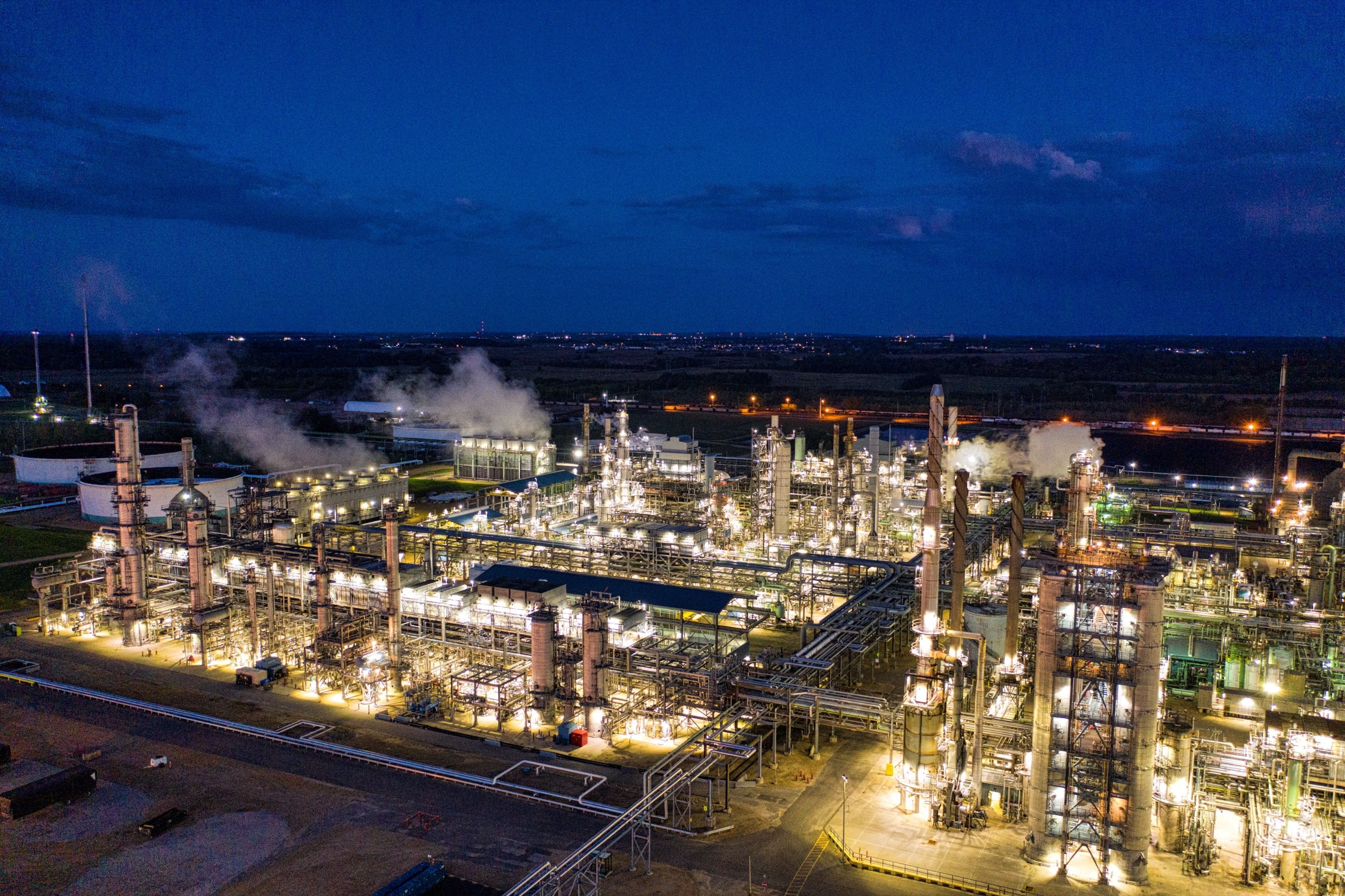An oil and gas refinery lit up at night, one of the energy corridors AfriGrown supplies